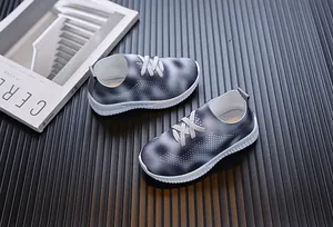 Détail du tissu flyknit respirant à dégradé gris sur baskets slip-on pour filles