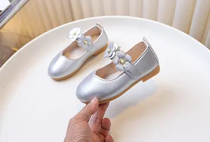 Close-up of silver Mary Jane shoes with 3D flowers, pearls, and non-slip gum sole