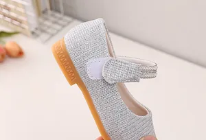 Close-up of silver glitter girls' Mary Jane shoes with elegant pearl strap detailing
