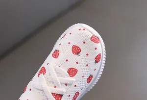 Détail de chaussures respirantes pour bambins avec imprimé fraise et semelle antidérapante