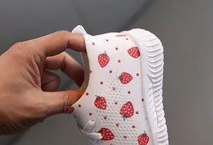 Gros plan montrant la haute élasticité et le tricot doux des chaussures bébé fraise