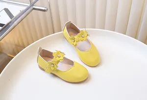 Detail of yellow Mary Jane flat shoes with leather flower and pearl ornament