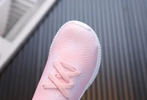 Gros plan de baskets roses en maille pour enfants avec semelles blanches antidérapantes
