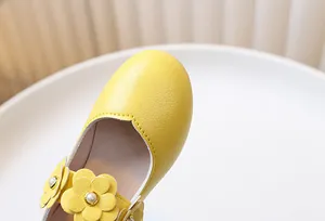 Detail of yellow girl's Mary Jane shoes with 3D leather flowers and pearl accents