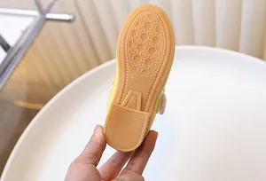 Detailed macro view of the anti-slip honeycomb rubber sole on yellow girls' shoes