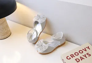 Details von silbernen Pailletten Mary Janes mit Tüllschleife und Strassverzierung