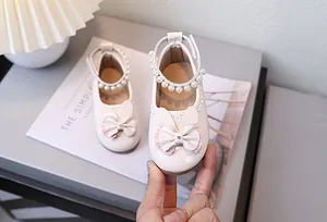 Details von rosa Lackleder Mädchenschuhen mit Hasenohren und Perlenriemen