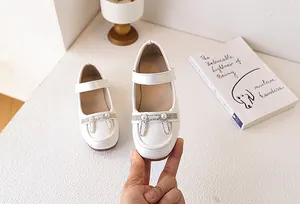 Dettaglio di scarpe Mary Jane bianche per bambina con decoro a orecchie di coniglio in perle