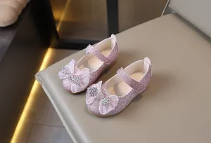 Detalle de merceditas rosas con purpurina y lazo de diamantes de imitación