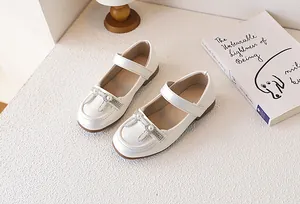Dettaglio di scarpa Mary Jane da bambina con fiocco di perle e cinturino a strappo