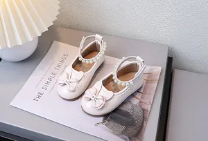 Detailansicht des Perlen-Fesselriemens und der Schleife an beigen Mädchen-Schuhen