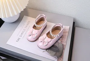 Detail von rosa Lackleder Mary Janes mit Perlen-Fesselriemen und süßen Hasenohren-Akzenten