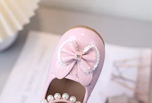 Details von rosa Prinzessinnenschuhen für Mädchen mit Perlenbesatz und Spitzenschleife