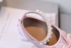 Detailansicht rosa Lackleder Mary Jane Schuhe für Mädchen mit Perlenriemen und Schleife
