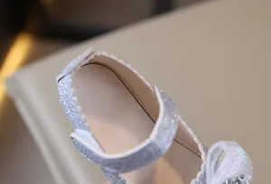 Detalle de merceditas plateadas con purpurina, lazo de lentejuelas y centro de strass