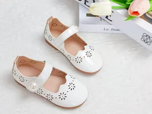 Détail de chaussures Mary Jane blanches avec fleurs découpées et gros bouton perle