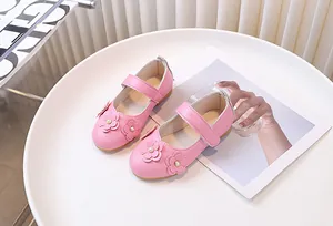 Detalle de zapatos Mary Jane rosas para niñas con flores en 3D y detalles de perlas