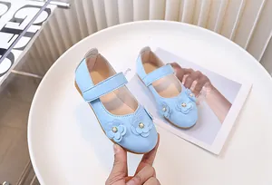 Detalle de zapatos Mary Jane azul claro para niñas con flores 3D y de perlas
