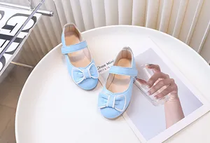 Dettaglio di ballerine Mary Jane azzurre con doppio fiocco e chiusura a strappo per bambina