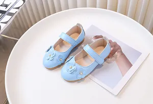 Detalle de zapatos Mary Jane azul claro para niña con flores y adornos de perlas