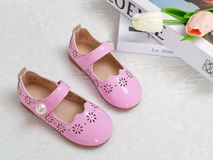 Détail de chaussures Mary Jane en cuir verni rose avec motifs floraux découpés au laser