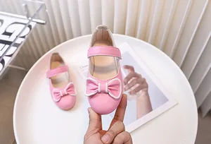 Dettaglio di scarpe Mary Jane rosa da bambina con fiocco e cinturino a strappo