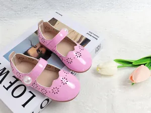 Détail de chaussures Mary Jane en cuir verni rose avec motif floral et perle élégante