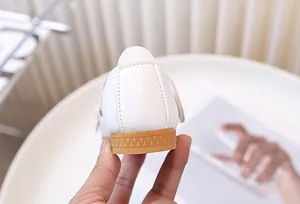 Detalle de la textura de cuero sintético blanco y la suela de goma antideslizante del zapato