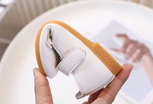 Primer plano que muestra la alta flexibilidad y suela de goma flexible del zapato para bebé