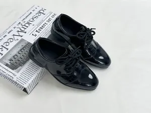 Polished black patent leather boys shoes with crocodile texture detail and laces