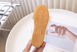 Vista detallada de la suela de goma antideslizante en zapatos blancos para niños talla 29