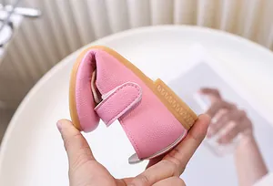 Dettaglio delle scarpe flessibili in pelle rosa per neonati con suola in gomma morbida