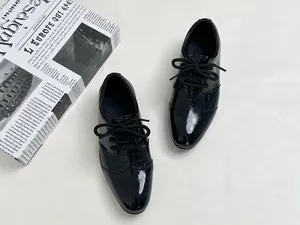 Top view of boys black patent leather shoes with embossed crocodile texture details