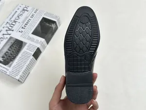 Detail of the non-slip rubber sole with size 28 marking on boys' black leather shoes