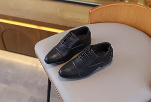 Gros plan détaillé de chaussures Oxford classiques en cuir noir pour garçons avec texture