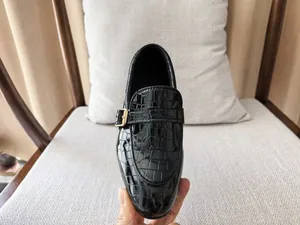 Detail of boys' black faux crocodile leather loafers with decorative gold metal buckle