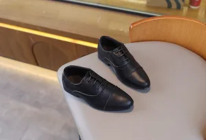 Détails de chaussures richelieu en cuir noir pour garçons avec une texture grainée