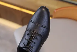 Détail de chaussures oxford vintage noires pour garçons avec texture grainée et lacets