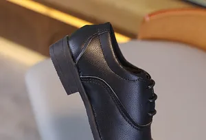 Vue macro d'une chaussure en cuir noir pour garçon avec une texture grainée de qualité
