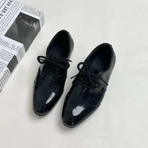 Classic boys black patent leather oxford shoes with textured crocodile pattern accents
