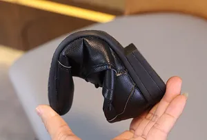 Chaussures souples en cuir noir pour garçon montrant la flexibilité de la semelle