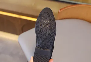 Vue détaillée de la semelle en caoutchouc antidérapante des chaussures en cuir noir garçon