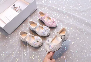 Détail de chaussures de princesse pailletées avec nœud en tulle et pendentif coeur