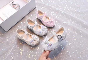 Détail de chaussures Mary Jane scintillantes avec nœuds en paillettes rose et argenté