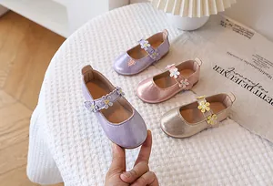 Close-up of glitter girls' Mary Jane shoes with 3D floral details and velcro strap