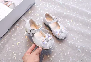 Détail de chaussures Mary Jane argentées à paillettes avec nœud en dentelle pour fille