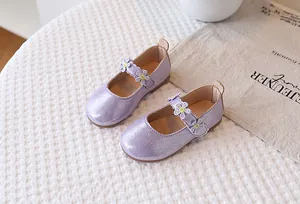Macro detail of purple sequined Mary Jane shoes with white daisy floral decorations
