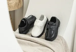 Detailed macro view of boys' formal black and beige leather shoes with non-slip rubber soles