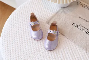 Close-up of purple glitter Mary Jane shoes featuring delicate lace flower appliques