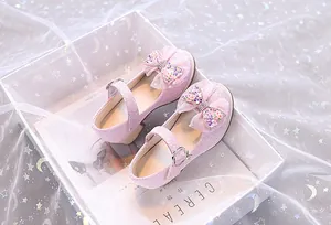 Détail de chaussures Mary Jane à paillettes roses avec nœud dans une boîte cadeau